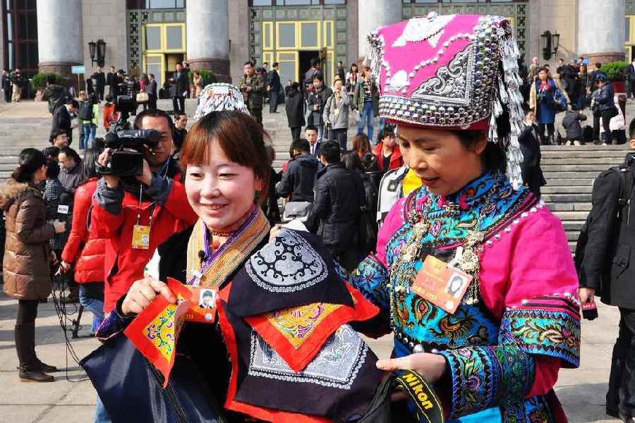 云南代表团的两位女代表在为记者展示她们带来的民族特色手工艺品。 人民网记者 马丽娅 摄