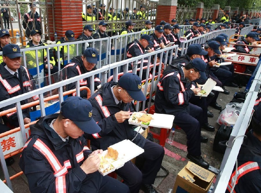 日前“一例一休”争议，大批警力如临大敌，驻守“立法院”，避免抗议民众翻墙进入“立法院”，饭点到了就地吃便当