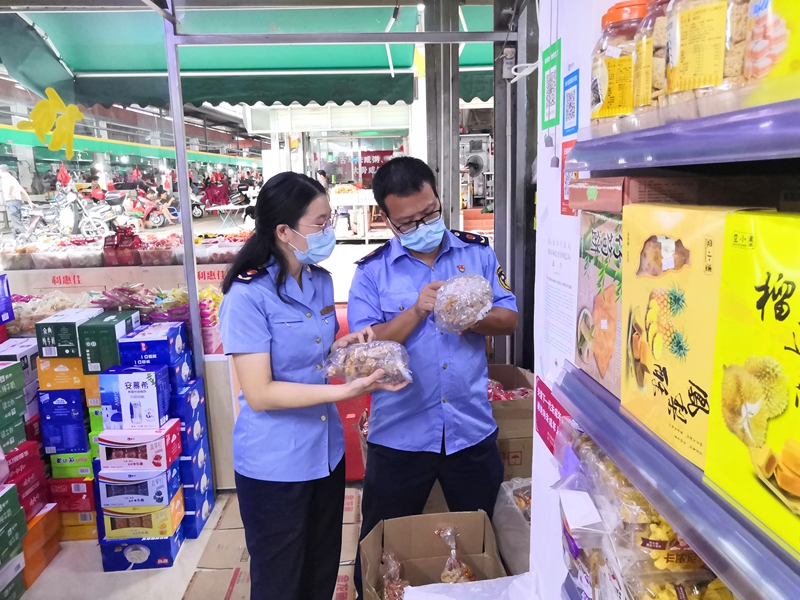 执法人员检查预包装食品标识标签信息（区市场监管局供图）.jpg